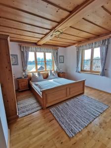 a bedroom with a bed and two windows at Haus Schrei in Grundlsee