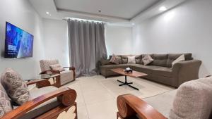 - un salon avec un canapé et une table dans l'établissement Luxurious Two bedroom Apartment In Gold Crest Mall And Apartment's, à Lahore