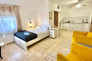 a bedroom with a large bed and a kitchen at Studio in the center with BBQ Patio and parking in Nahariyya