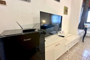a living room with a flat screen tv and a piano at Studio in the center with BBQ Patio and parking in Nahariyya