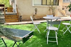 a table and chairs and a grill in the grass at Studio in the center with BBQ Patio and parking in Nahariyya