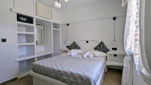 a bedroom with a bed in a white room at Anoi House by the sea Agios Fokas Tinos in Tinos Town