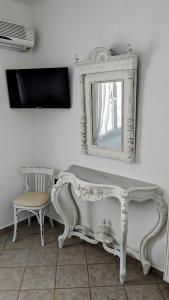 a white bench and a mirror and a chair at Anoi House by the sea Agios Fokas Tinos in Tinos Town