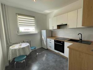 a kitchen with a table and a white refrigerator at Jagiellonka in Malbork
