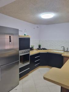 eine Küche mit blauen Schränken und einem Kühlschrank aus Edelstahl in der Unterkunft צימר רמון in Mitzpe Ramon
