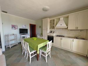 cocina con mesa y mantel verde en Appartamento Rosa di Chia, en Chia