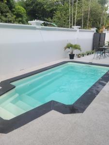 a swimming pool with blue water in a backyard at Gated Riverside Studio Apartment in San Juan