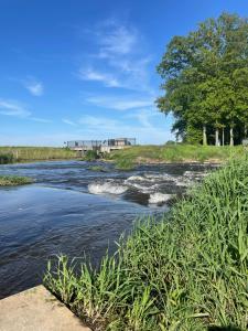 a river with a bridge in the background at Ferienhaus direkt an der Hase in Quakenbrück