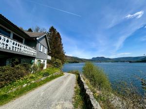a house on a road next to a body of water at Magnar in Etnesjøen