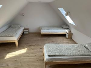 Cette chambre mansardée comprend 3 lits. dans l'établissement Jula - apartamenty w Kudowie-Zdrój, à Kudowa-Zdrój