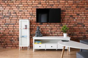 a living room with a tv on a brick wall at Apartament nr 12 in Gdańsk