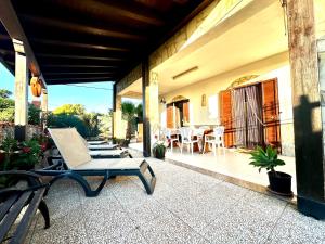 un patio con una silla y una mesa en un porche en Casa del Sole, en Campofelice di Roccella