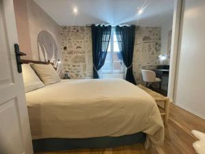 1 dormitorio con 1 cama grande y escritorio en Le jardin de l'Ostal, en Casteljaloux