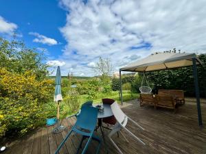 una terraza con mesa, sillas y sombrilla en La Mandragora - Maison Vernon Giverny, en Vernon