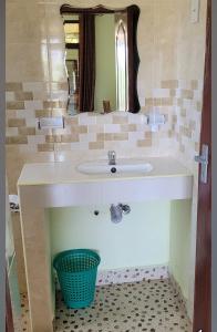 uma casa de banho com um lavatório e um espelho em Mtwapa june apartment 4 em Mtwapa