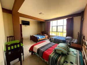 1 dormitorio con 2 camas y ventana en HOSTAL GALO, en Tarija