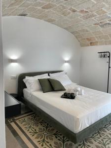 a bedroom with a large bed with white sheets at Dimora Santa Teresa in Monopoli