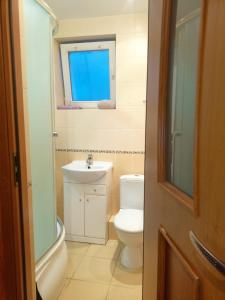 uma casa de banho com um WC, um lavatório e uma janela em Centrum Apartament Legionów 48m2 em Konin