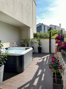 una bañera de hidromasaje en un patio con flores en Studio Apartment Rosa Krk en Krk