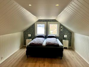 a bedroom with a large bed in a attic at Magnar in Etnesjøen