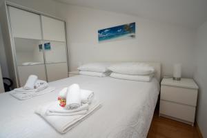a bedroom with a white bed with towels on it at Adriatic Escape Novalja-Zrce! in Novalja