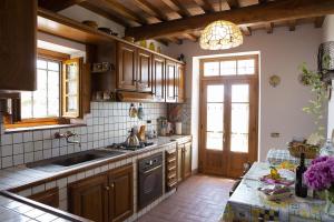 una cocina con armarios de madera y fregadero en Villa Rachele, en Larciano