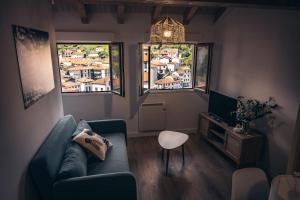 a living room with a couch and two windows at Apartamento Villa Carlota in Cudillero