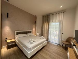 a bedroom with a large white bed and a window at Arial Trinity Suites in Vlorë