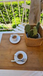 una mesa con dos tazas de café y un cactus en 12 living, en Ancona