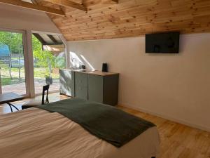 a bedroom with a bed and a kitchen with a window at Bajkowy Domek 2 nad rzeką Liwiec in Łochów