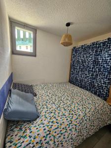 ein Schlafzimmer mit einem Bett in einem Zimmer mit einem Fenster in der Unterkunft Appartement idéalement placé face au lac in Soustons
