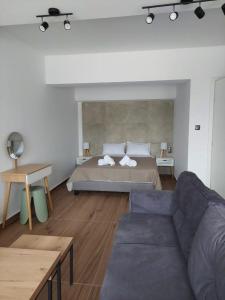 ein Schlafzimmer mit einem Bett und einer Couch in der Unterkunft Mannou Studio in Paralia Vrachou