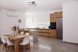 a kitchen with a wooden table and white appliances at Rajmonda Apartment in Lezhë