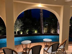 a patio with chairs and a swimming pool at night at Maison d'Orange - La Pinede in Saint-Tropez