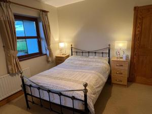 a bedroom with a bed and two dressers and a window at Country Hideaway in Limerick