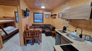uma cozinha e sala de estar numa pequena casa em Domki Sowia Polana em Dąbki