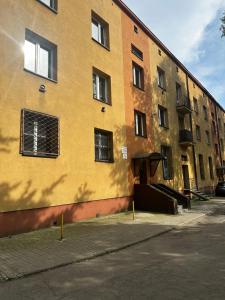un edificio giallo con finestre sul lato di Apartament Helenka a Zabrze