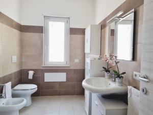 ein Badezimmer mit einem Waschbecken, einem WC und einem Spiegel in der Unterkunft La GreenHouse - Isola di Capo Rizzuto in Isola Capo Rizzuto
