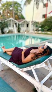 uma mulher deitada numa jangada ao lado de uma piscina em Seawood beach front resort em Morjim