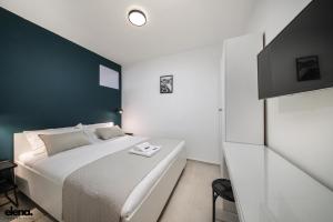 ein Schlafzimmer mit einem weißen Bett und einer schwarzen Wand in der Unterkunft Studio apartment Elena in Rijeka