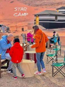 Una donna e un bambino in piedi accanto a un uomo di STAR CAMP & WiTH TOR a Wadi Rum
