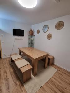 a dining room with a wooden table and bench and a tv at Appartment im Untergeschoss in Freilassing
