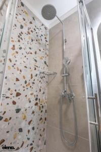 eine Dusche in einem Badezimmer mit einer mit Steinen bedeckten Wand in der Unterkunft Studio apartment Elena in Rijeka + 21 Fotos