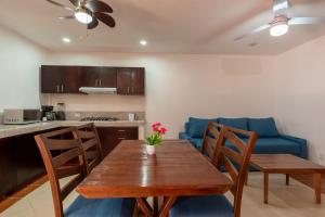 kuchnia i jadalnia z drewnianym stołem i niebieską kanapą w obiekcie New Tranquil Oasis in Puerto Vallarta w mieście Puerto Vallarta