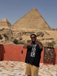 een man staat voor de piramiden bij El Khalil Pyramids Inn in Caïro