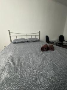 Łóżko z szarą kołdrą i dwoma brązowymi przedmiotami w obiekcie Okno Na Rynek -Pokoje Paris -Parking w Kielcach
