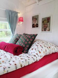 1 dormitorio con cama con edredón y almohadas en BAUWAGEN Lilly in Hemmoor, en Hemmoor