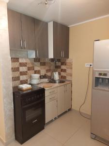 a kitchen with a stove and a refrigerator at Vikendica Nika in Palić