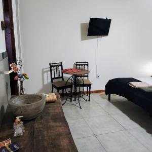 a room with a table and chairs and a bed at Hostel e Pousada Dom Bosco in São João del Rei