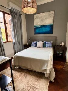 a bedroom with a bed and a painting on the wall at Buenos Aires, Recoleta, Capital Federal in Buenos Aires